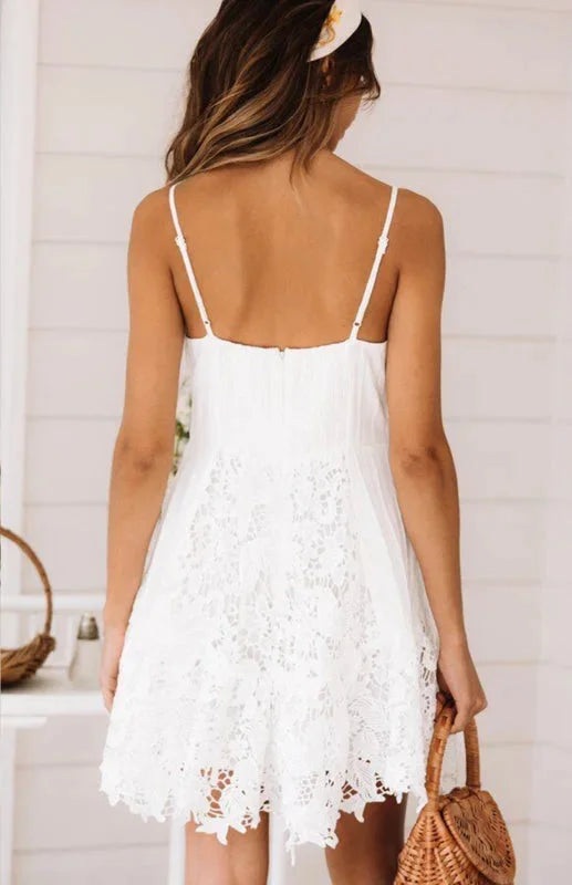 White lace v-neck mini dress with delicate spaghetti straps, feminine and elegant design perfect for special occasions.