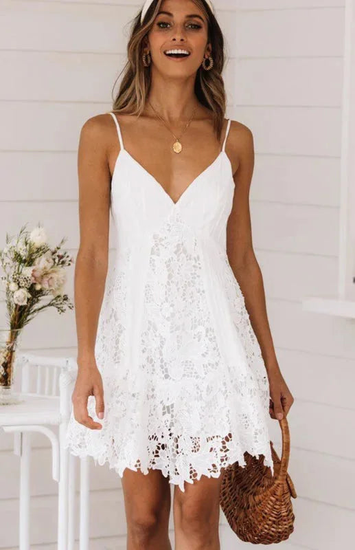 White lace v-neck spaghetti strap mini dress showcasing intricate lace detailing and a flattering silhouette.