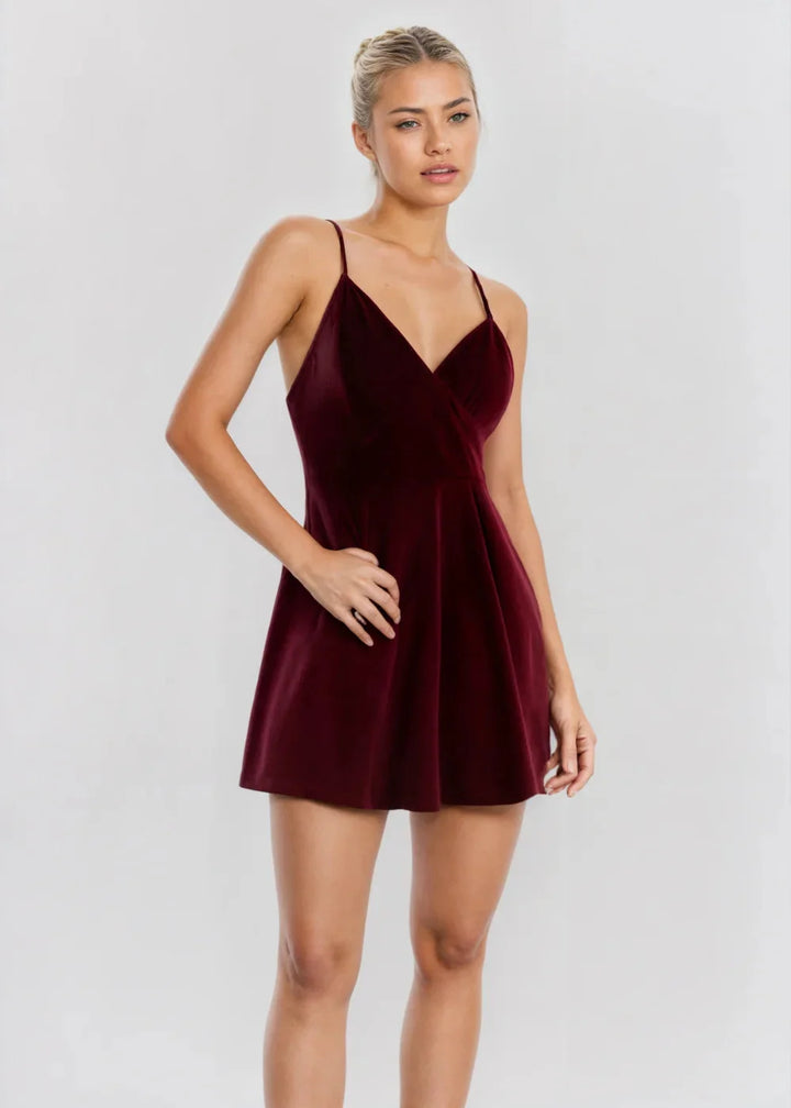 Burgundy velvet skater dress with V-neck showcasing rich red color and soft fabric texture.