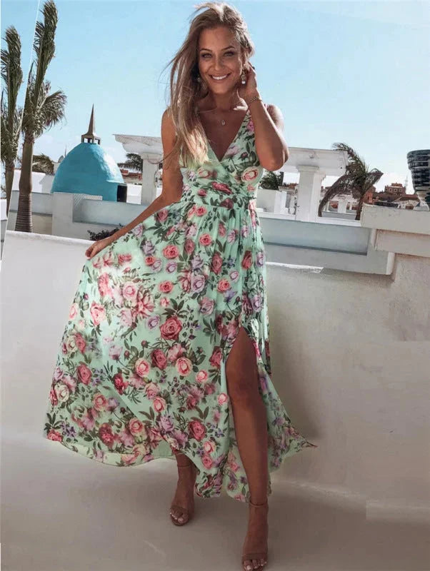 Light green sleeveless maxi dress with split-front design, adorned with floral patterns. Perfect for a breezy and stylish…