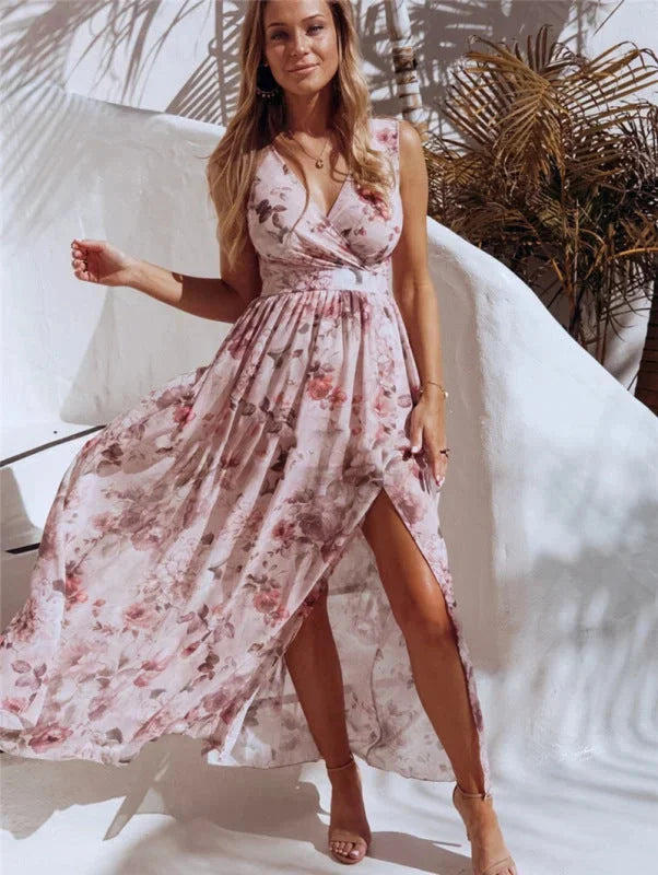 Pink sleeveless maxi dress with split-front and floral design. Made of lightweight, flowy fabric perfect for summertime…