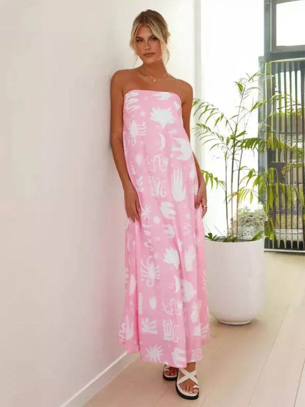 Pink strapless maxi dress with vibrant prints in flowy design. Perfect for a breezy summer day out.