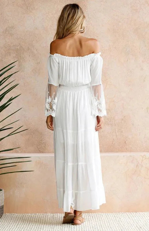 White off-shoulder tiered dress with delicate lace sleeves, perfect for a feminine and trendy look.