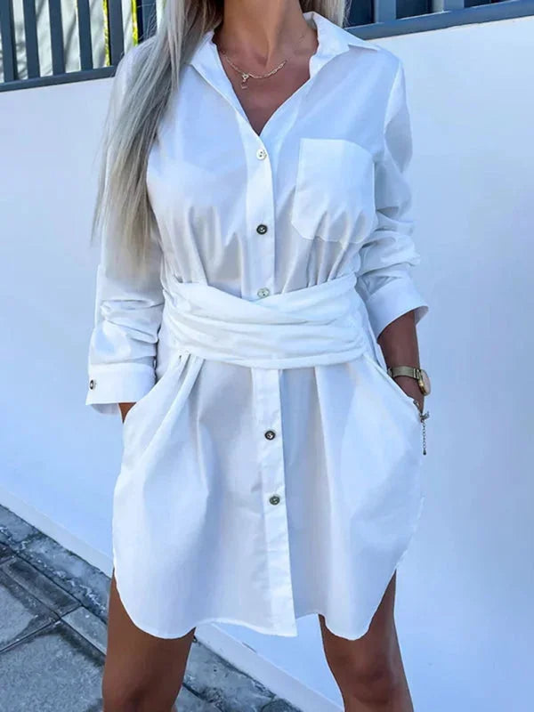 White shirt dress with belted waist and adjustable sleeves. Versatile and stylish design, perfect for any occasion.