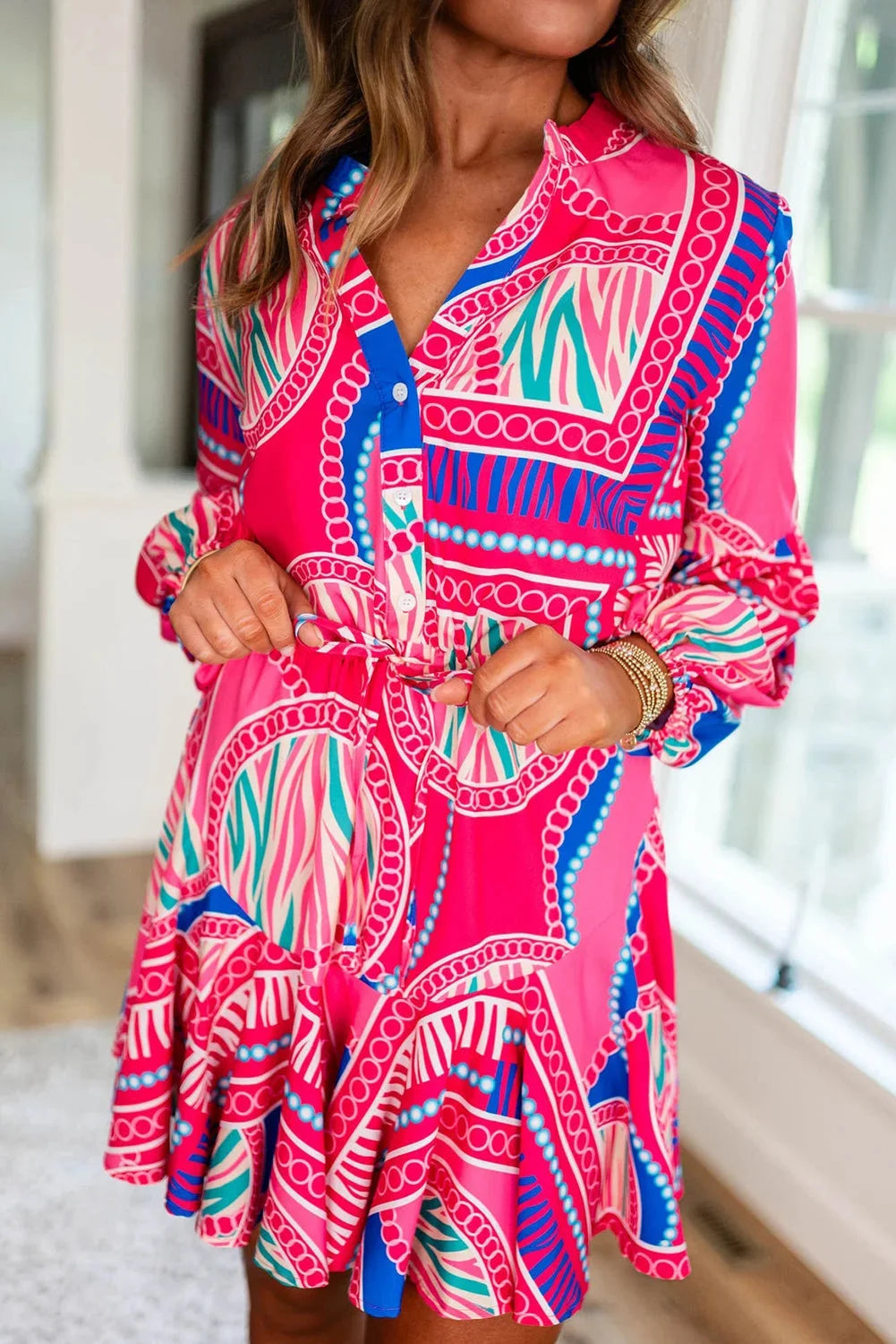 "Vibrant pink tribal print mini dress with unique patterning and lightweight fabric, perfect for a stylish summer look."