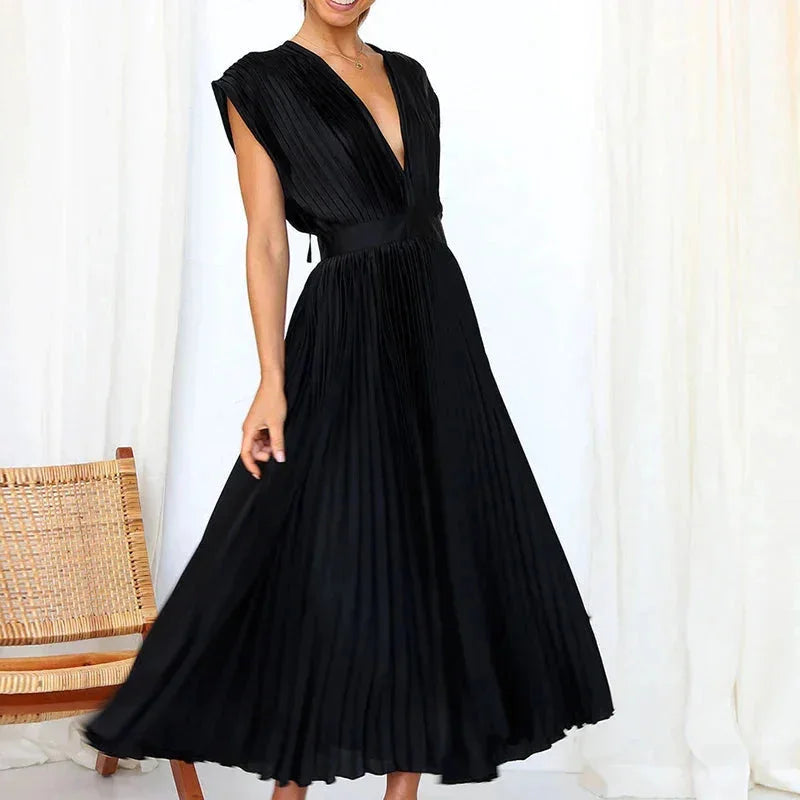 "Ursula pleated dress with deep V-neckline in navy, showcasing a modern silhouette and elegant pleats."