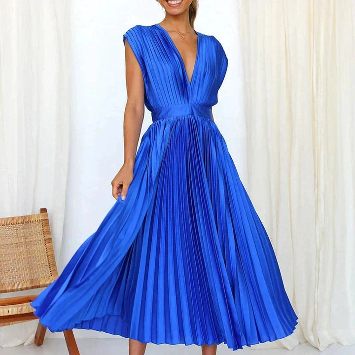 Blue pleated dress with deep V-neckline, showcasing effortless elegance and a flattering silhouette for any special occasion.