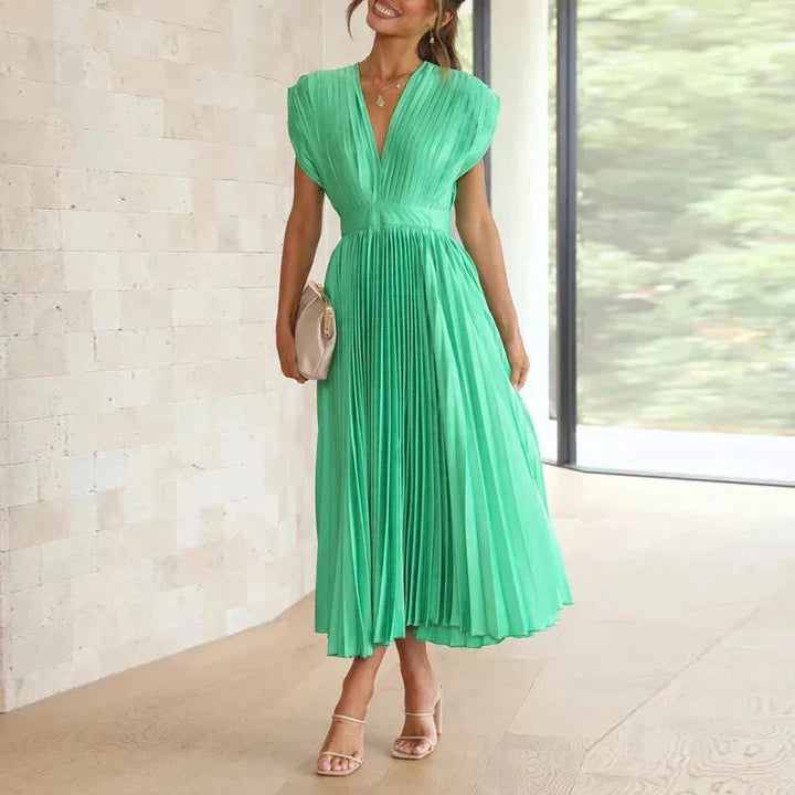 Green pleated dress with V-neckline, flowing silhouette. Made from lightweight, breathable fabric. Perfect for any occasion.