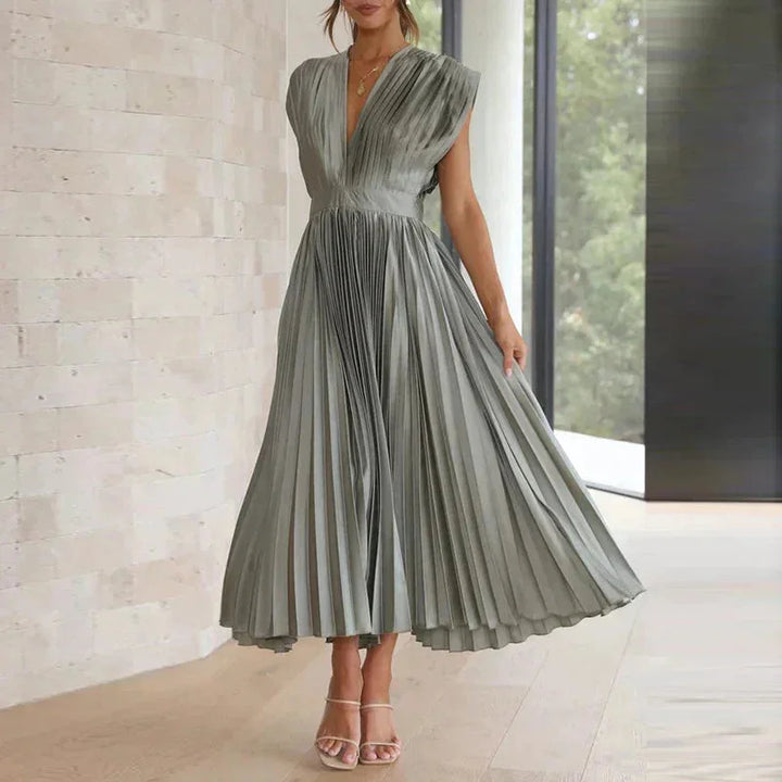 Grey pleated dress with deep V-neckline, sophisticated and chic. Made from soft and comfortable fabric for a flattering look.