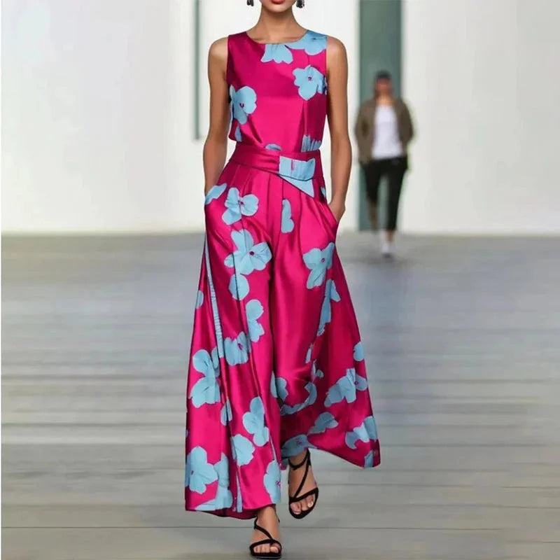 Sleeveless pink maxi dress with blue floral design, perfect for a summer day out, adorned with a breezy flowy fabric.