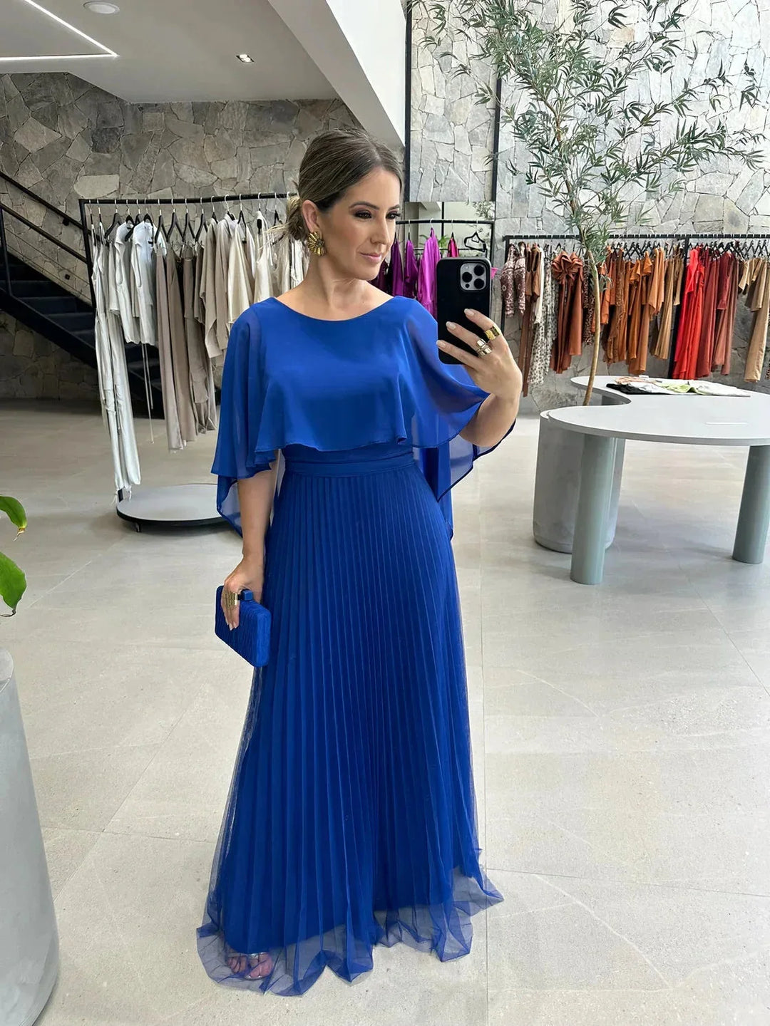 Blue floor-length dress with flowing sleeves by Weslynn. Made from soft silk fabric with a loose silhouette for elegant…