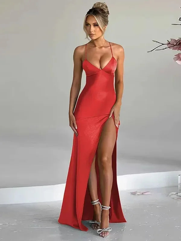 Black halter neck evening dress with high slit, showcasing elegant design and flowing silhouette.