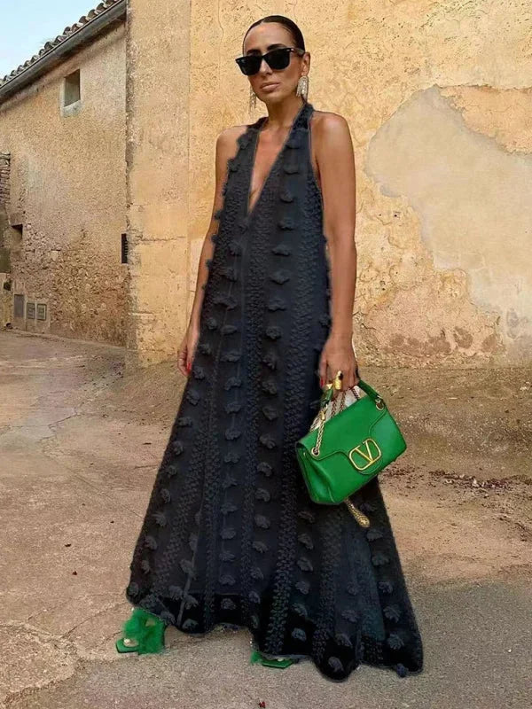 Black halter neck maxi dress featuring intricate floral details, ideal for a chic and stylish look.