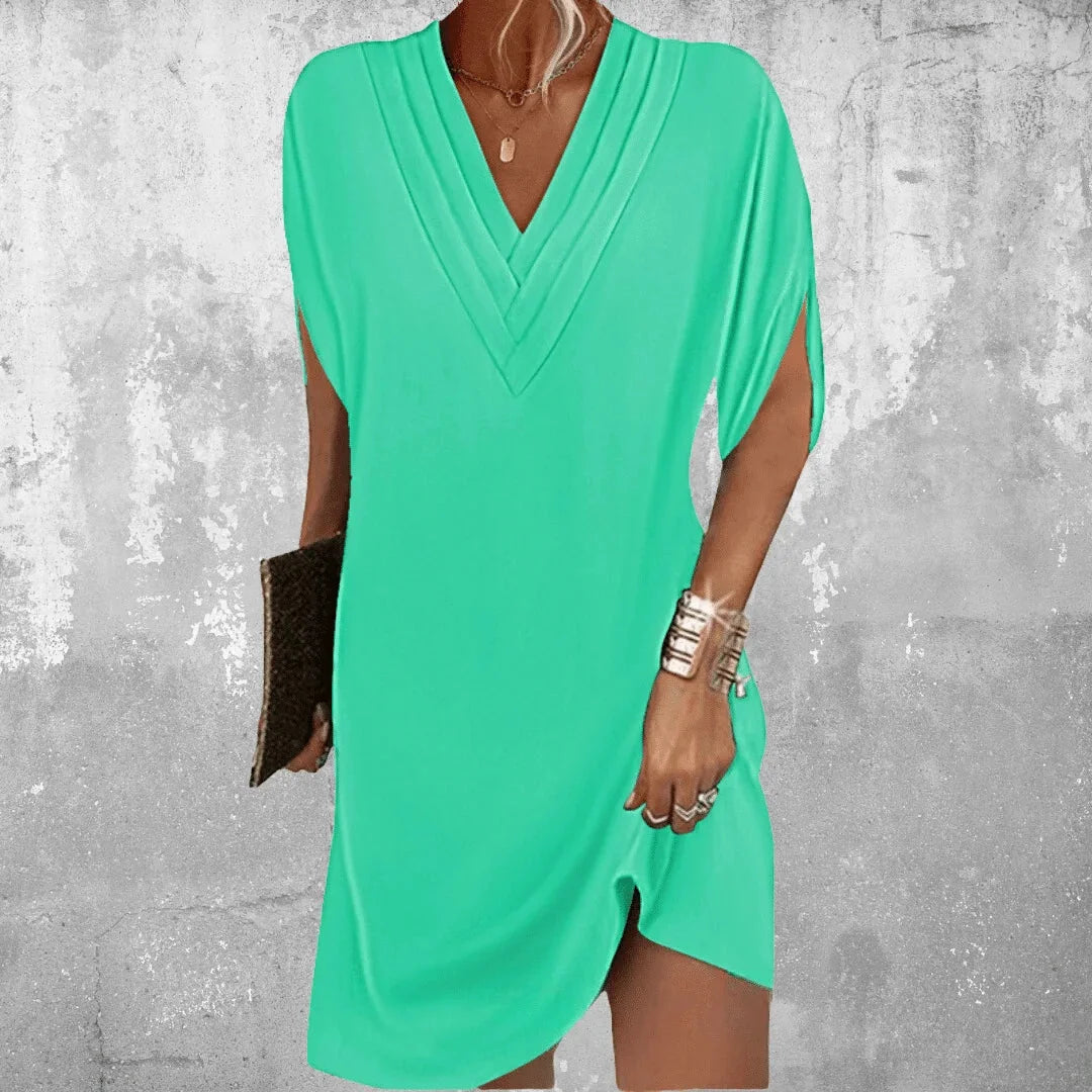 Bright green V-neck mini dress with slit sleeves, perfect for effortless elegance. Made of soft textured fabric.